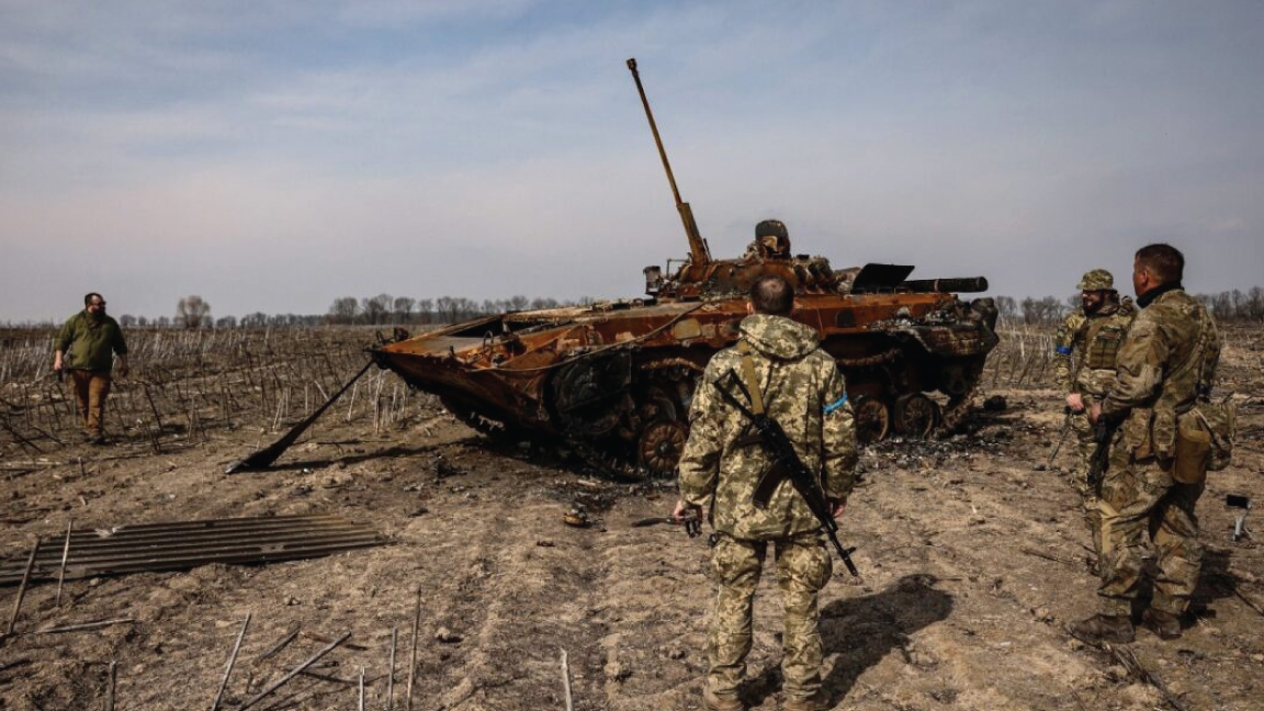 جنود أوكرانيون يتحلقون حول دبابة روسية محترقة في خاركيف