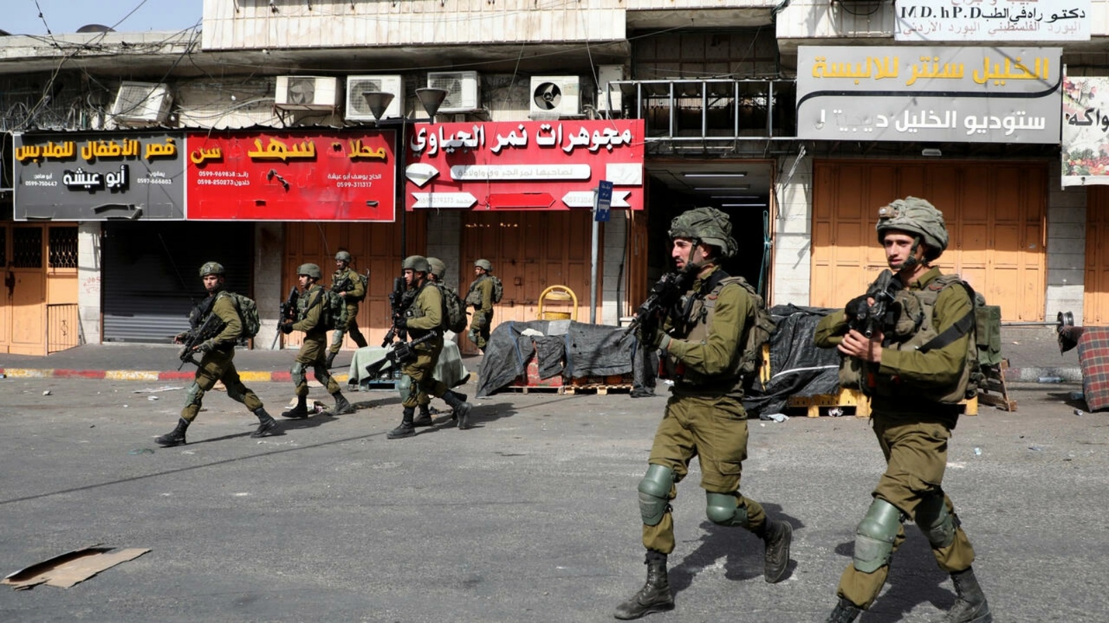 جنود إسرائيليون يمشون خلال مواجهات مع متظاهرين فلسطينيين في مدينة الخليل في الضفة الغربية المحتلة في 29 مايو 2022 ضد مسيرة الأعلام الإسرائيلية في القدس الشرقية المحتلة