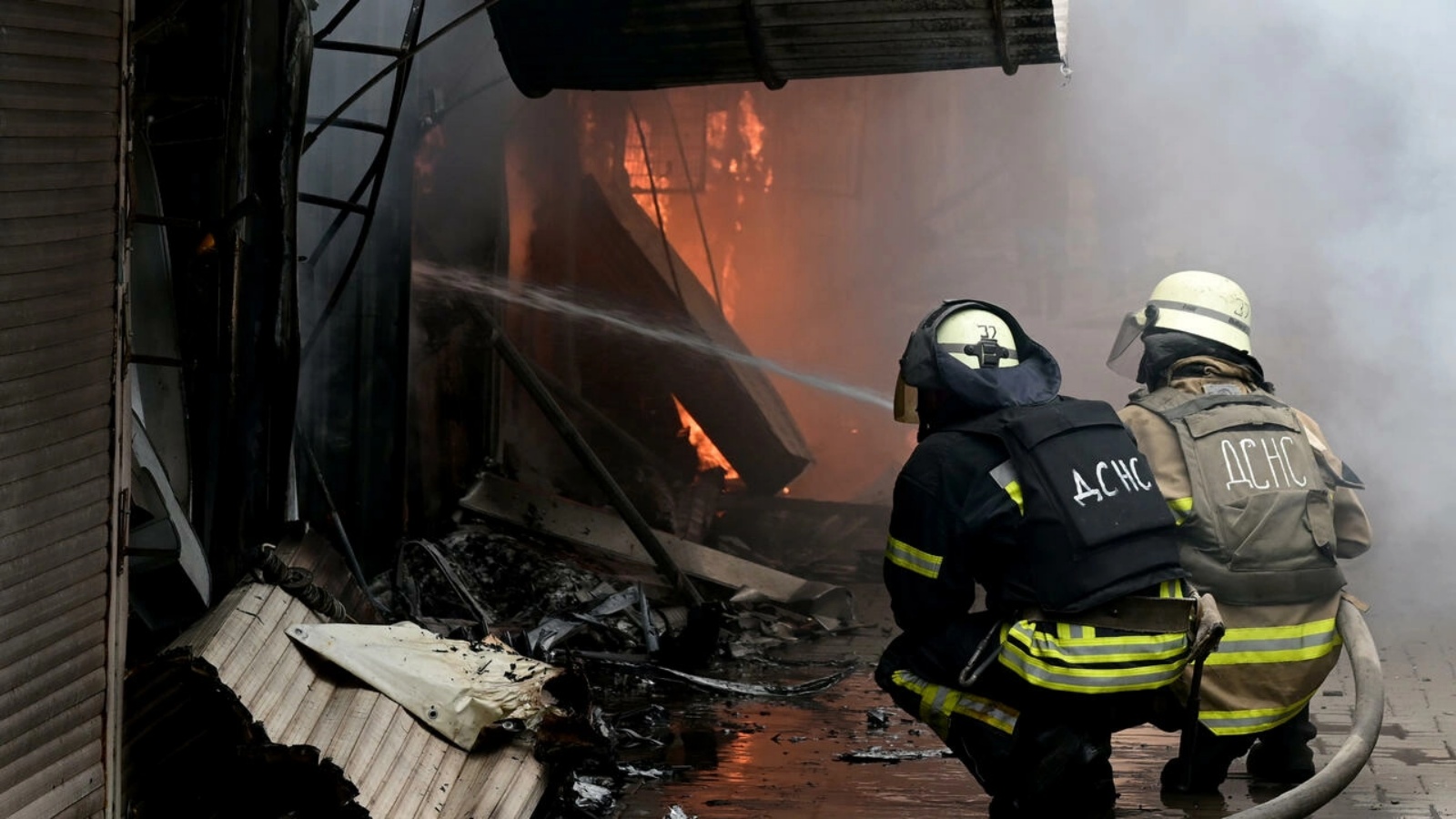 عناصر اطفاء يحاولون اخماد حريق في سوق سلوفيانسك في أوكرانيا جراء قصف روسي في الخامس من يوليو 2022