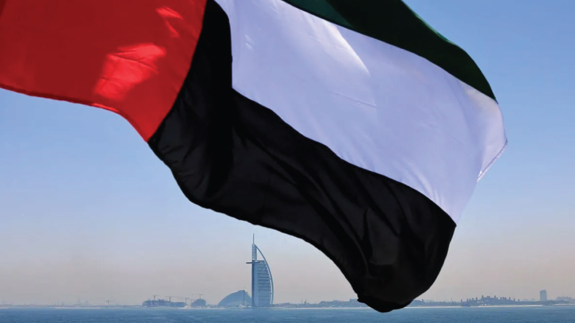 تُظهر هذه الصورة التي تم التقاطها في 3 يونيو 2021 علمًا إماراتيًا يرفرف فوق مرسى دبي مع فندق برج العرب في الخلفية