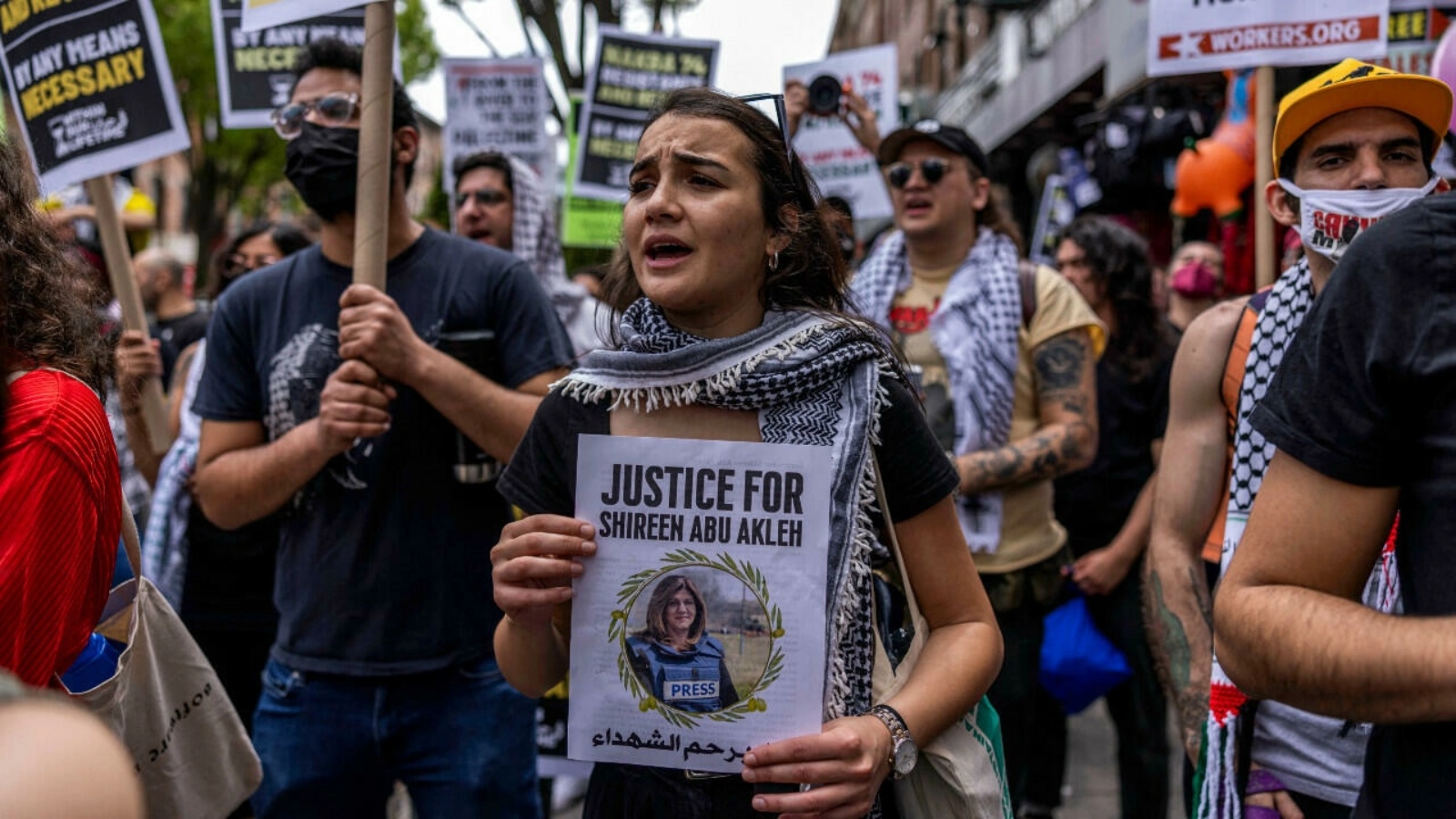 متظاهرة بحي باي ريدج في بروكلين بمدينة نيويورك الأمريكية، تحمل صورة الصحافية الفلسطينية شيرين أبو عاقلة التي قتلت برصاص إسرائيلي، 15 مايو 2022.