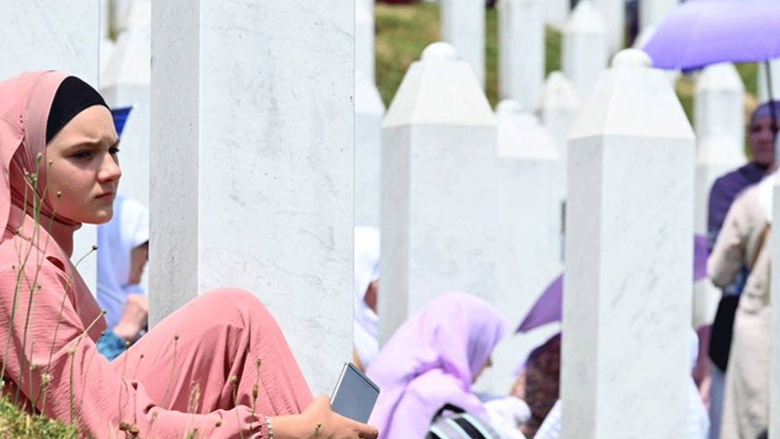 نساء مسلمات البوسنة، الناجيات من مذبحة سريبرينتسا 1995، يبكين بالقرب من قبور أقاربهن، في المقبرة التذكارية في قرية بوتوكاري، في 11 تموز\يوليو 2021.