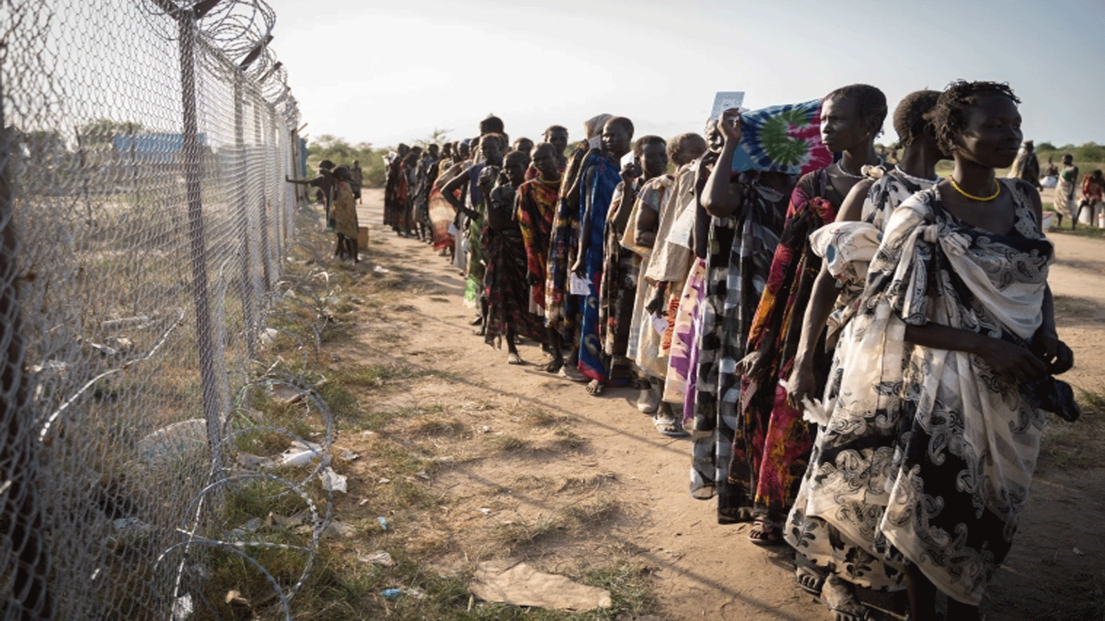 نساء من مجموعة المورلي العرقية ينتظرن في طابور لتوزيع الغذاء من قبل برنامج الغذاء العالمي التابع للأمم المتحدة في جوموروك، جنوب السودان، في 10 يونيو 2021، حيث تعرضت قريتهم مؤخرًا للهجوم من قبل مجموعة مسلحة