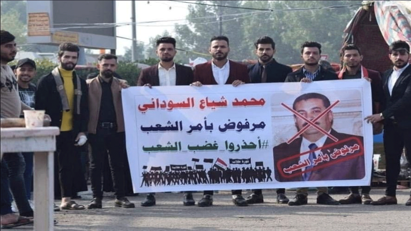 محتجون يرفعون لافتة رفض لترشيح محمد شياع السوداني (تويتر)