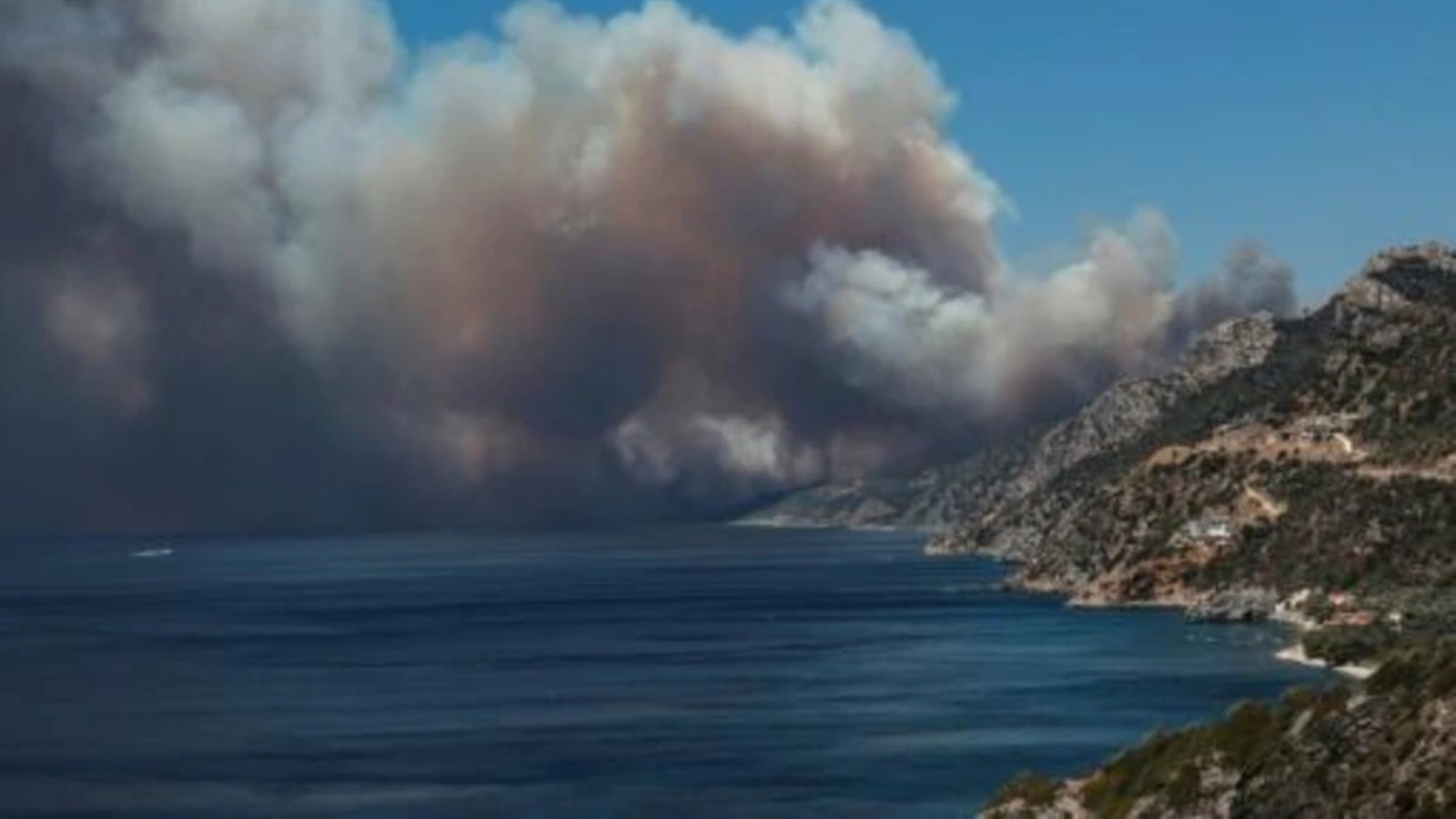 دخان يرتفع بفعل حريق في غابة بالقرب من منتجع فاتيرا في جزيرة ليسبوس في اليونان، في 23 يوليو 2022