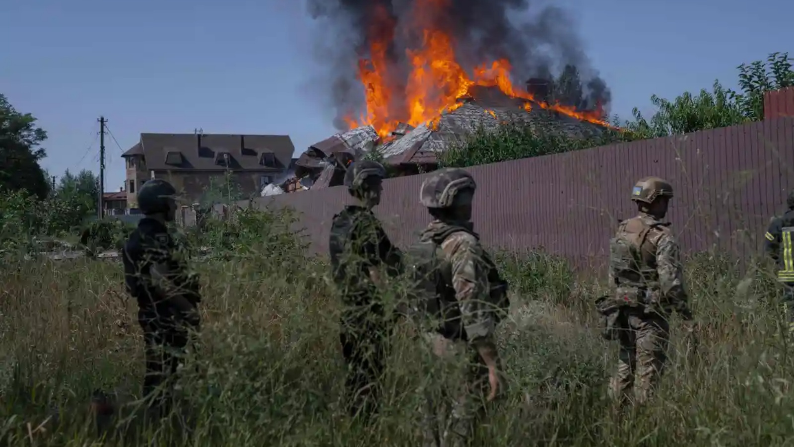 جنود أوكرانيون خارج منزل محترق أصابته قذيفة في ضواحي باخموت