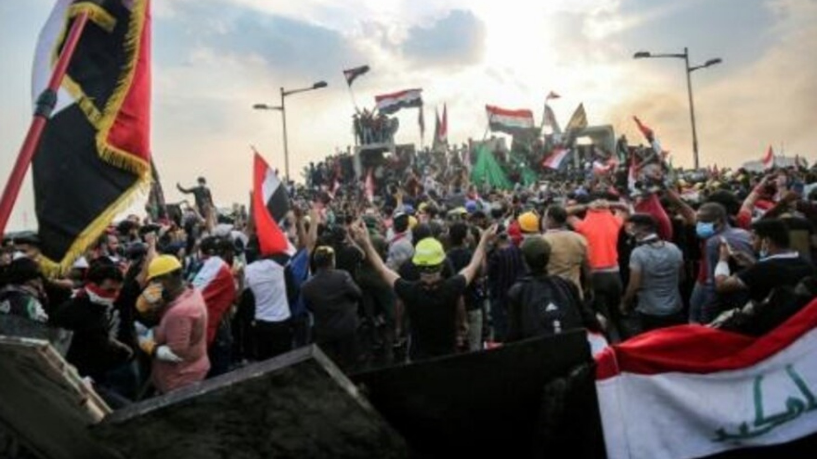 صورة من الأرشيف لمتظاهرين عراقيين يلوحون باعلام البلاد في العاصمة بغداد في 29 أكتوبر 2019