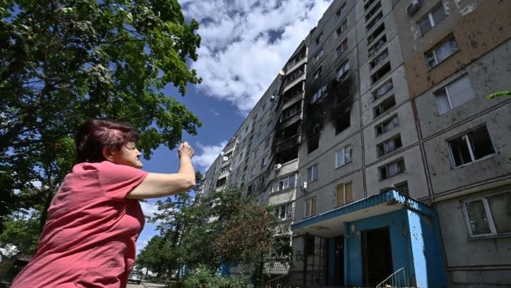 أحد السكان المحليين ينظر إلى مبنى سكني متضرر في سالتيفكا، وهي منطقة شمالية في ثاني أكبر مدينة أوكرانية في خاركيف في 31 يوليو 2022، وسط الغزو الروسي لأوكرانيا