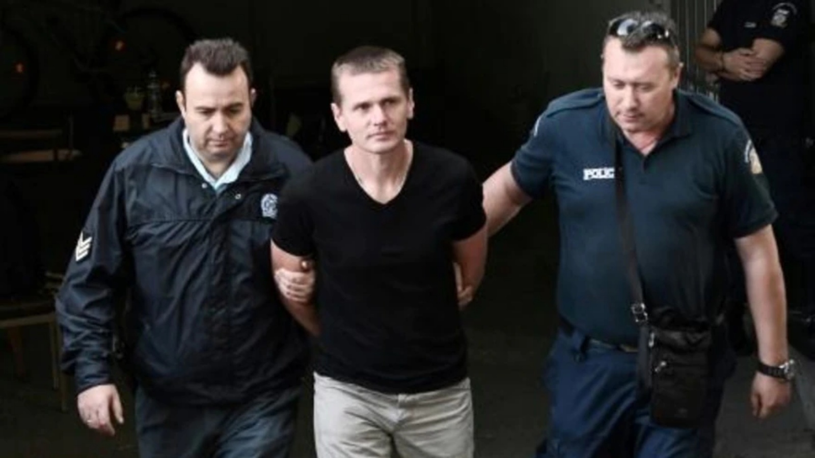 صورة التُقطت في 4 أكتوبر 2017 تُظهر الخبير الروسي بالعملات المشفّرة ألكسندر فينيك برفقة عنصريْن من الشرطة لدى وصوله إلى محكمة في سالونيكي في اليونان