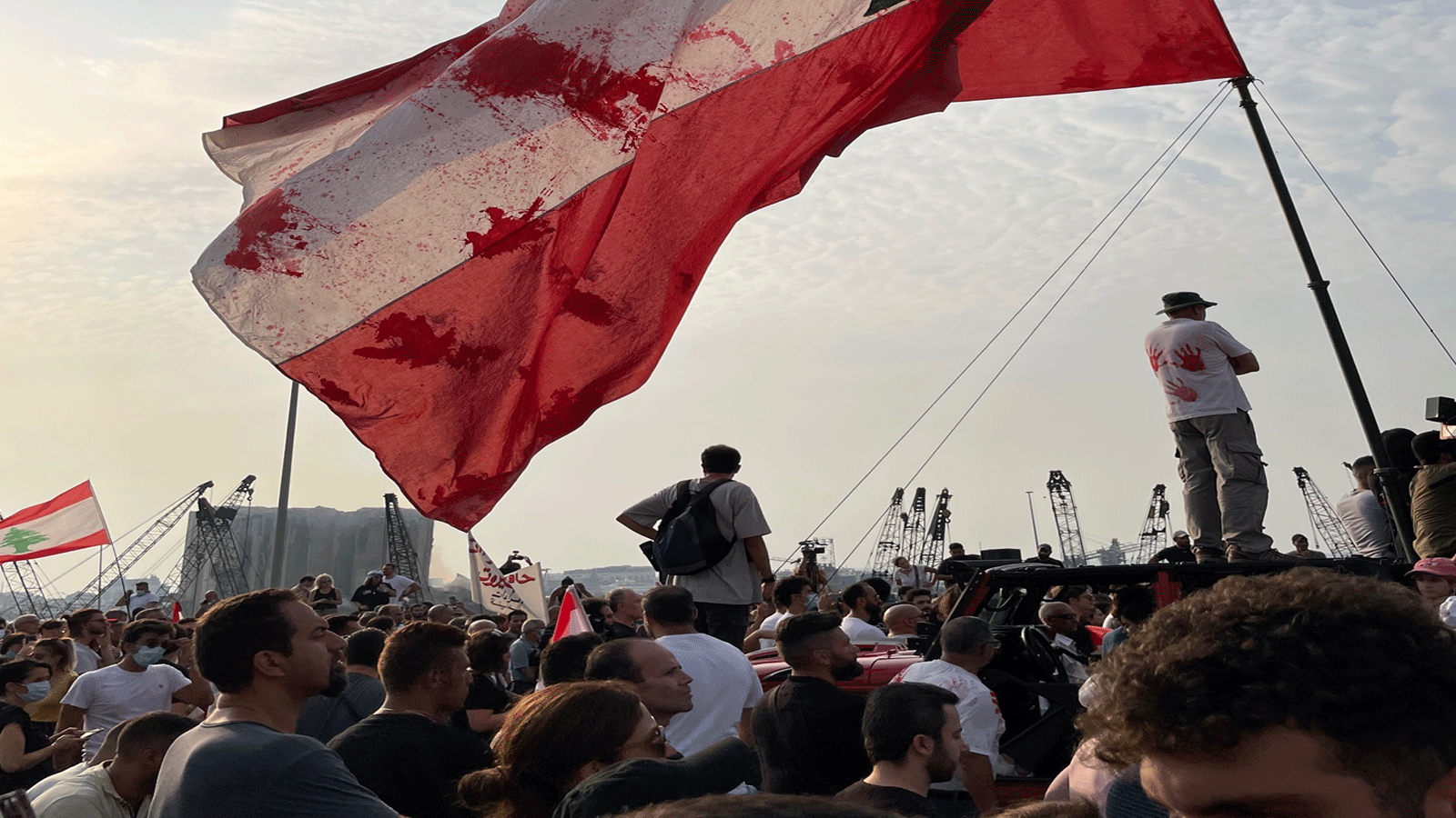 صورة متداولة عبر تويتر للمتظاهرين ويظهر العلم  اللبناني الملطخ بالأحمر في إشارة لدماء الضحايا