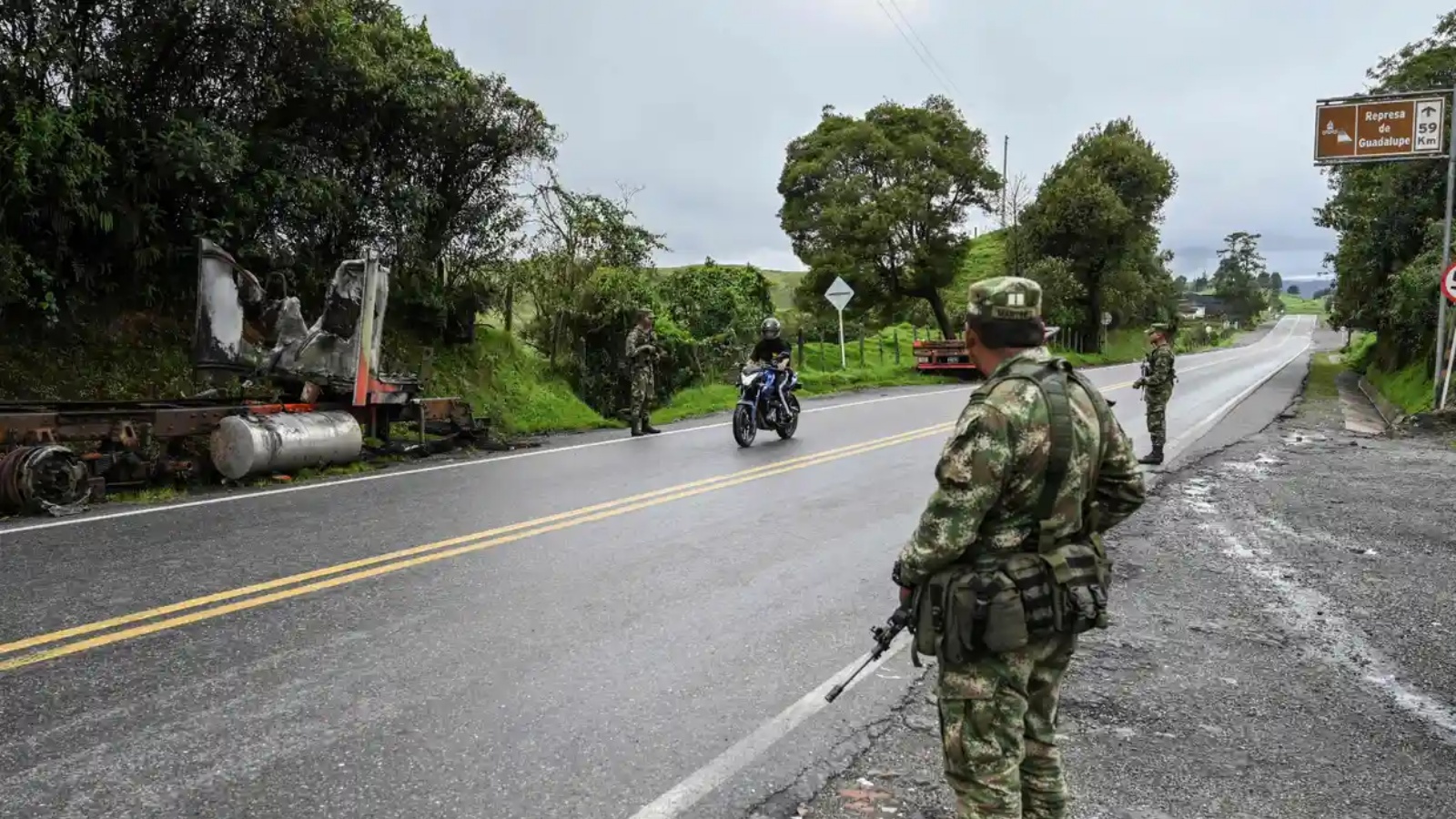 جنود كولومبيون يقفون في حراسة بجوار شاحنة أحرقها أعضاء من عصابة 