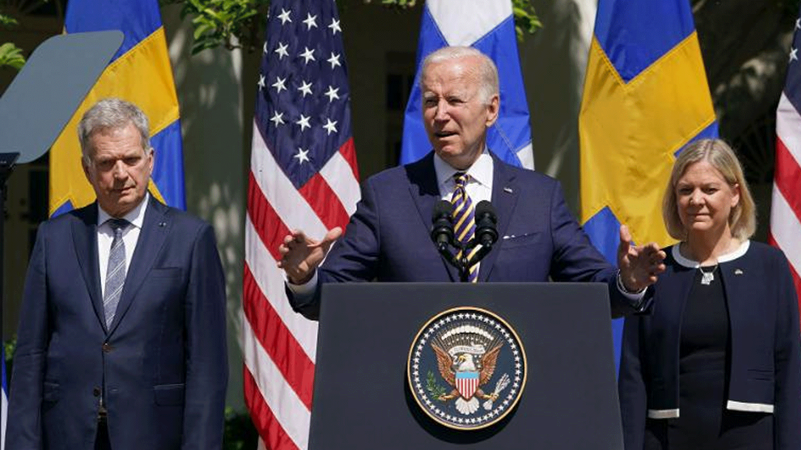  الرئيس الأمريكي جو بايدن، محاطًا برئيسة الوزراء السويدية ماغدالينا أندرسون ورئيس فنلندا سولي نينيستو، وهو يتحدث في حديقة الورود بعد اجتماع في البيت الأبيض في واشنطن العاصمة. 19 أيار\مايو 2022.