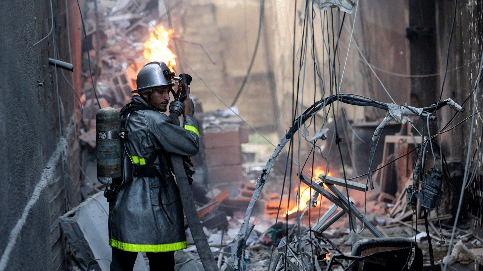 رجل إطفاء فلسطيني يتصدى للحريق وسط الدمار الذي أعقب غارة جوية إسرائيلية على مدينة غزة، فلسطين، 5 آب\أغسطس 2022