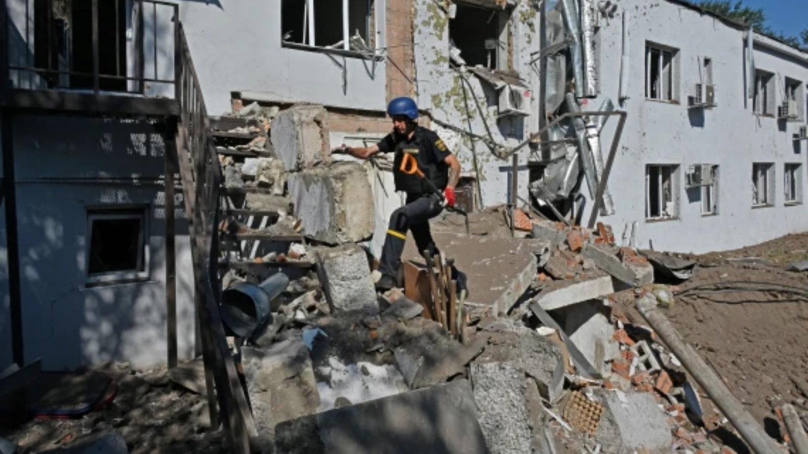 عامل إزالة الألغام الأوكراني يتسلق الأنقاض بالقرب من المبنى المتضرر لمختبر طبي سريري في خاركيف في 9 أغسطس 2022 