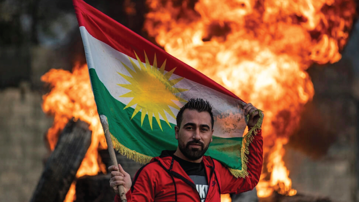 شخص يرفع العلم الكردي لمناسبة عيد النوروز في القامشلي بتاريخ 20 مارس 2020