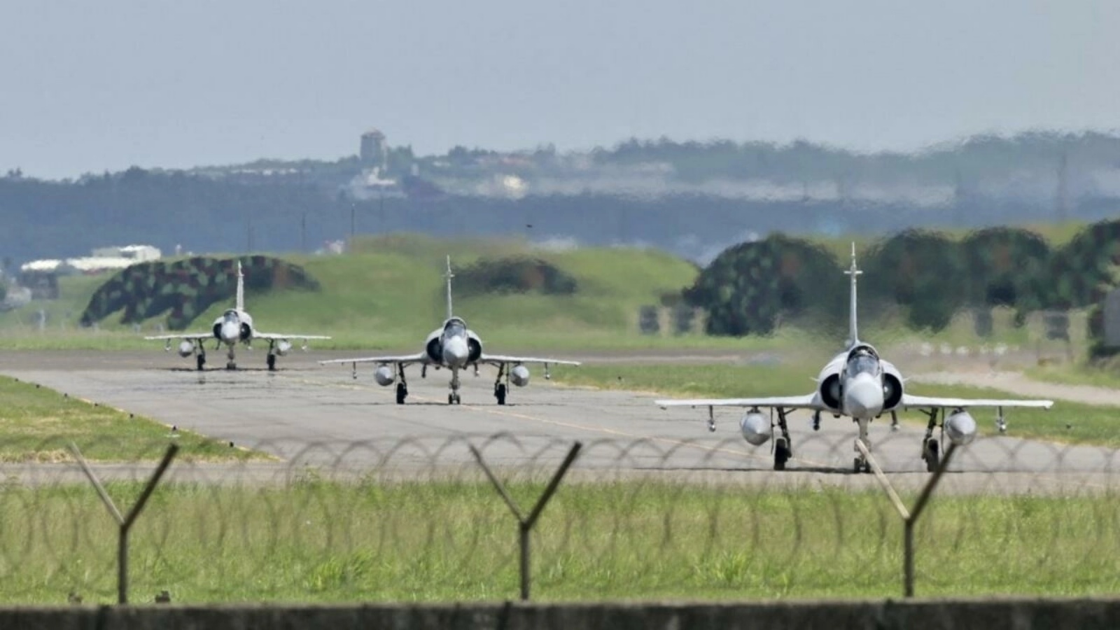 ثلاث طائرات مقاتلة فرنسية الصنع من طراز ميراج 2000 تاكسي على مدرج أمام حظيرة طائرات في قاعدة هسينشو الجوية في هسينشو، تايوان في 5 أغسطس 2022