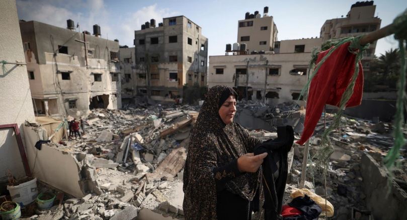 فلسطينية تعلق ثيابا التقطتها من بين الأنقاض في 8 أغسطس 2022 ، خارج منزلها الذي تضرر في الضربات الجوية الإسرائيلية الأسبوع الماضي في مدينة غزة