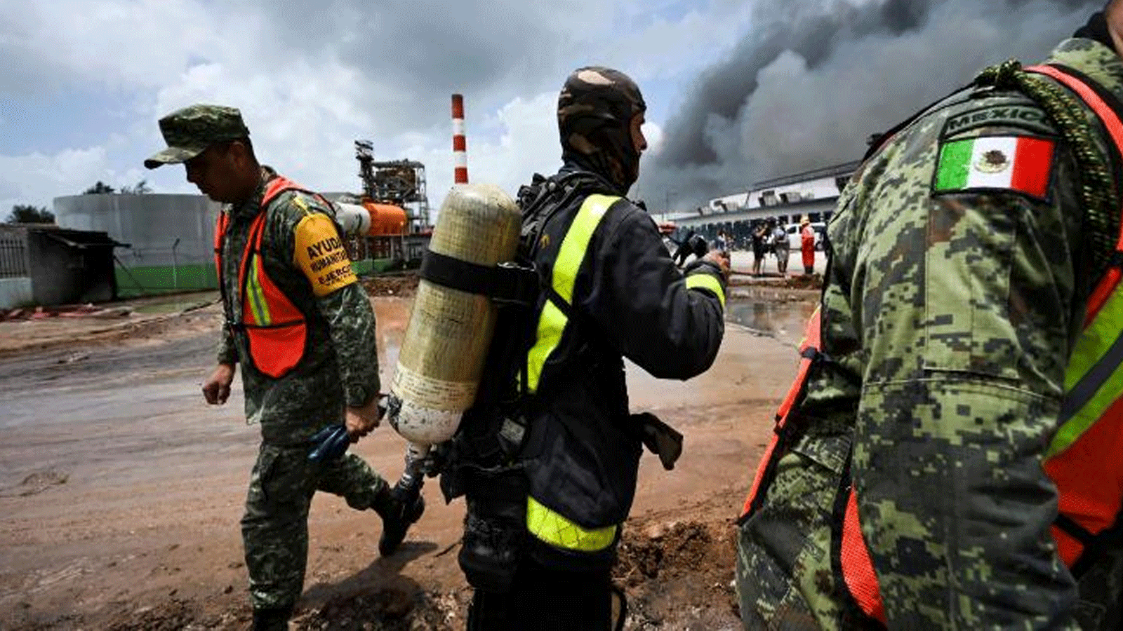 رجال إطفاء مكسيكيون وكوبيون يعملون على إخماد الحريق في مستودع الوقود الذي أشعلته صاعقة