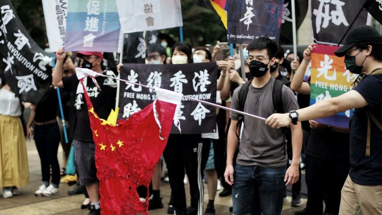صورة مؤرخة في 12 يونيو 2022 لناشطين في تايبيه يحرقون علما صينيا خلال تجمع لإحياء الذكرى الثالثة لبدء الاحتجاجات الضخمة المؤيدة للديموقراطية في هونغ كونغ عام 2019