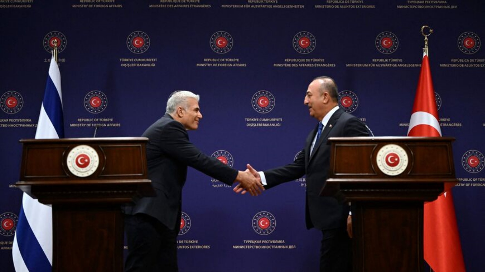 وزير الخارجية التركي مولود جاويش أوغلو (إلى اليمين) ووزير الخارجية الإسرائيلي آنذاك يائير لابيد (إلى اليسار) يتصافحان خلال مؤتمر صحفي في 23 يونيو 2022 في أنقرة.