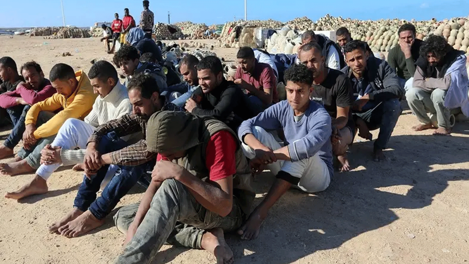 مهاجرون أنقذهم الحرس الوطني التونسي أثناء محاولة عبور البحر الأبيض المتوسط ​​بالقوارب، يستريحون على الشاطئ في ميناء القطيف في بن قردان في جنوب تونس بالقرب من الحدود مع ليبيا. في 15 كانون الأول\ديسمبر 2021