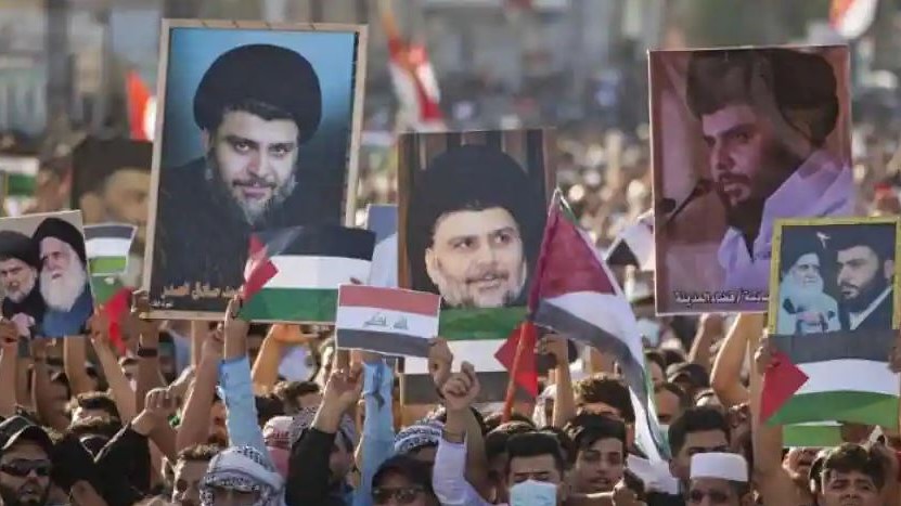 أنصار رجل الدين الشيعي مقتدى الصدر يحملون صورا له أثناء تجمعهم في إحدى التظاهرات بالعراق