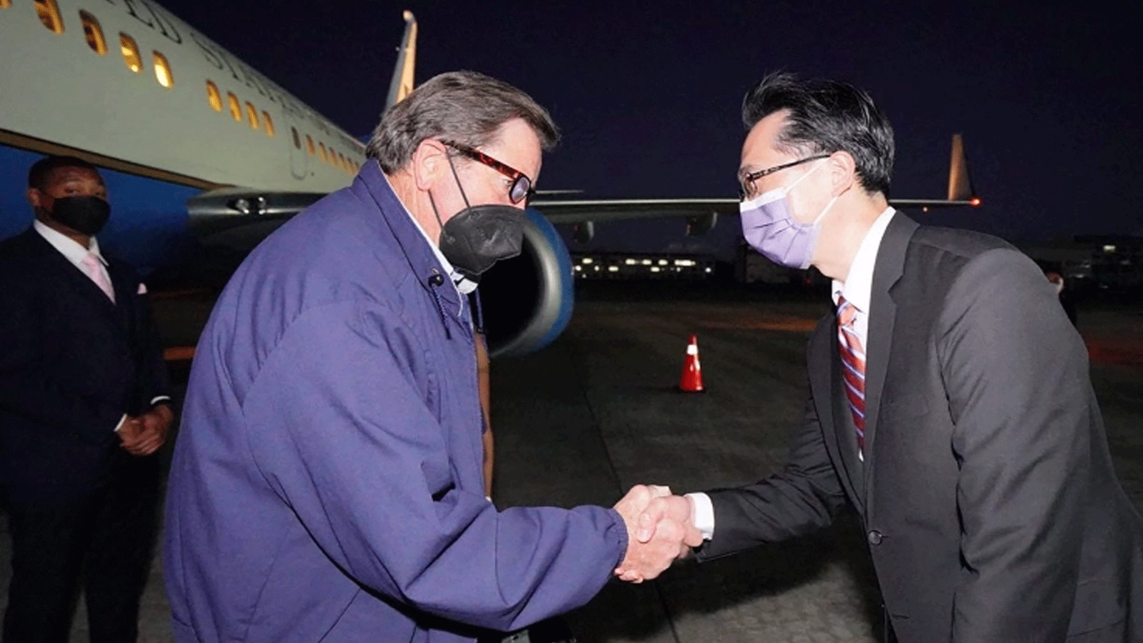 النائب الأميركي جون جاراميندي، إلى اليسار، يصافح الدبلوماسي التايواني دوغلاس يو تيان هسو عند وصوله إلى مطار سونغشان في تايبيه
