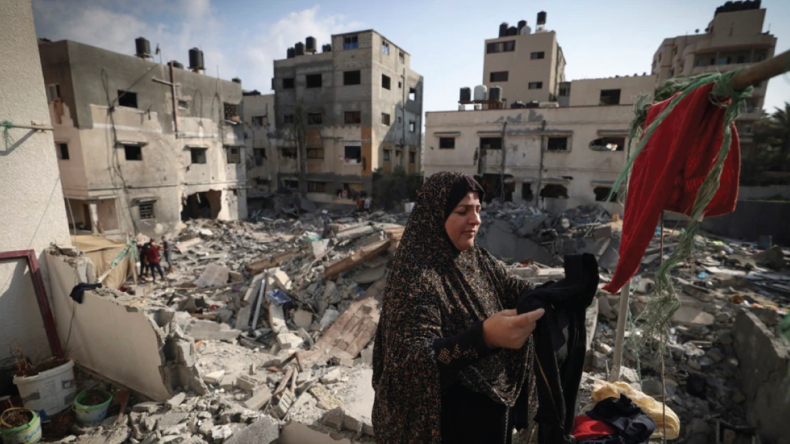 فلسطينية تعلق ملابس التقطتها من تحت الأنقاض في 8 أغسطس 2022، خارج منزلها الذي تضرر في غارات جوية إسرائيلية على مدينة غزة، بعد ساعات من سريان وقف إطلاق النار بين إسرائيل والجهاد الإسلامي