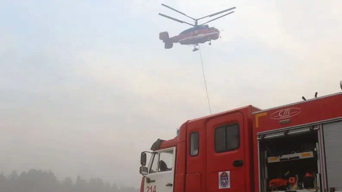 تظهر هذه الصورة التي نشرتها وزارة الطوارئ الروسية في 18 أغسطس 2022 طائرة هليكوبتر إطفاء وسيارة إطفاء تكافح حريقا هائلا في منطقة ريازان خارج موسكو