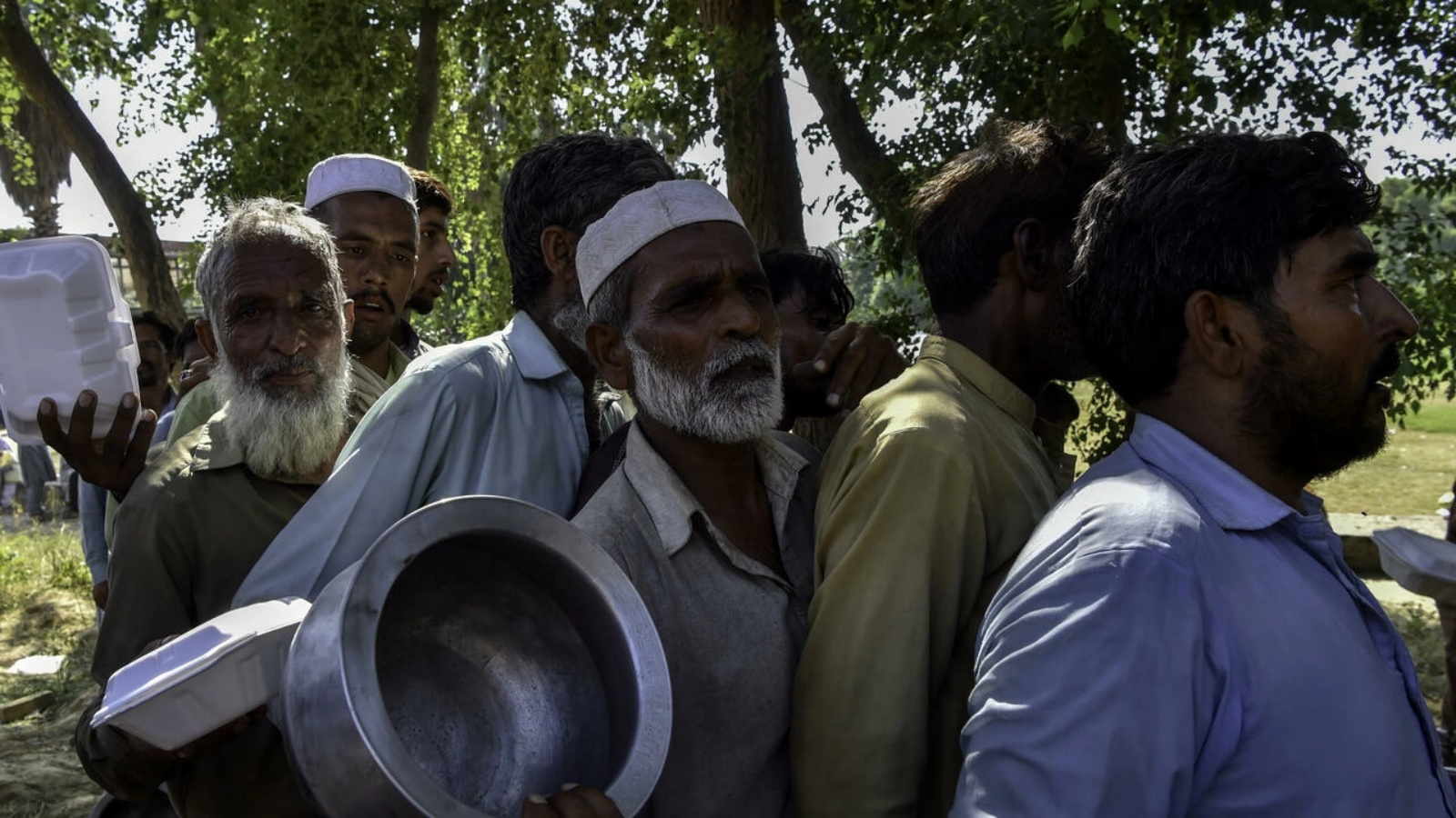 رجال يصطفون لإحضار الطعام لأسرهم في مخيم مؤقت في ناوشيرا، باكستان