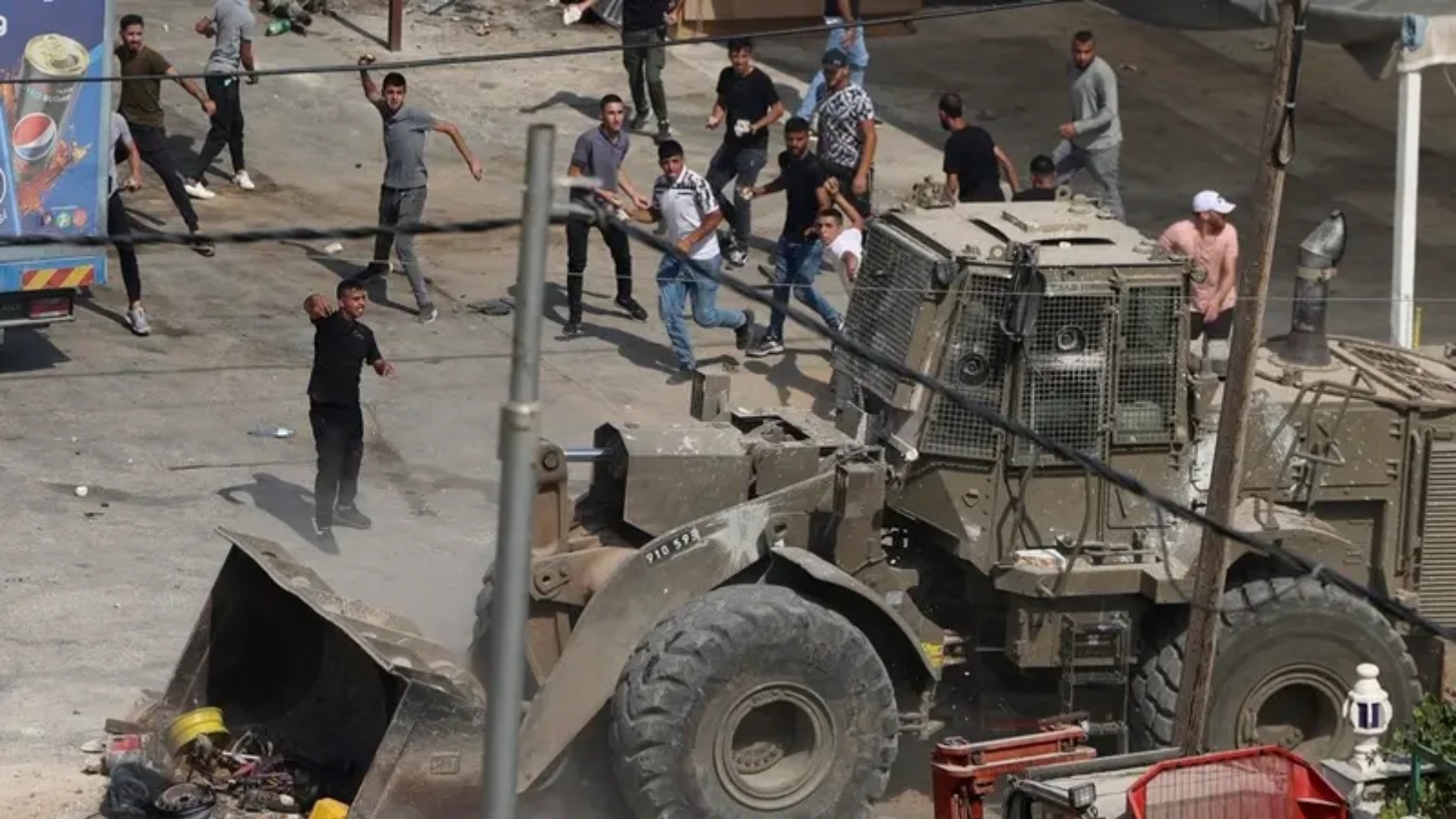 فلسطينيون يرشقون مركبات للجيش الإسرائيلي بالحجارة خلال اشتباكات في بلدة الرجيب شرق مدينة نابلس بالضفة الغربية المحتلة في 30 أغسطس 2022 ، بعد أن فتح فلسطينيون النار على إسرائيليين تسللوا إلى المدينة
