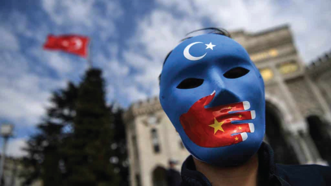 صورة التقطت في 1 أبريل 2021 تبين متظاهرًا يرتدي قناعا مرسومًا بألوان علم تركستان الشرقية يشارك في احتجاج لمؤيدي أقلية الأويغور في اسطنبول