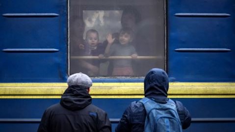 أطفال يلوحون من قطار في محطة كراماتورسك المركزية بينما تفر العائلات من مدينة كراماتورسك الشرقية في منطقة دونباس في 4 أبريل