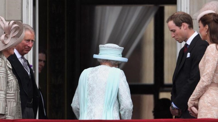 الملكة الراحلة تدخل من شرفة قصر وينسدور، وإلى يمينها الأمير هاري وزوجته ميعان، وإلى يسارها الأمير تشارلز الذي صار ملكًا وزوجته كاميلا