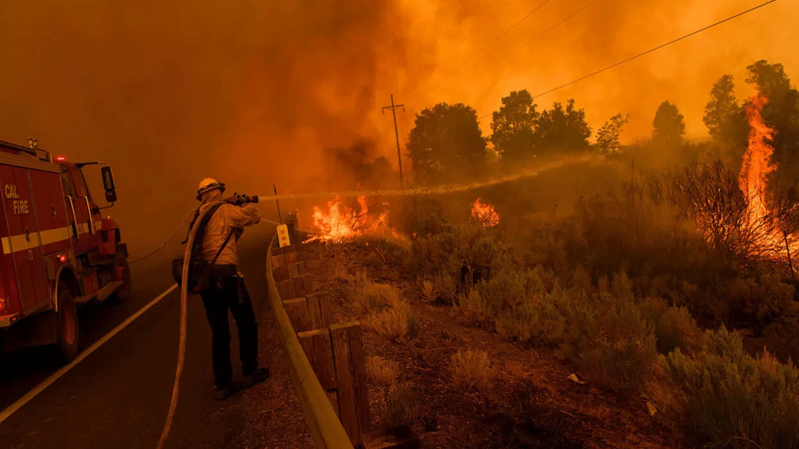  رجال إطفاء Cal Fire احتواء Dixie Fire يحاولون إطفاء الحريق على الطريق السريع 395 بالقرب من ميلفورد، كاليفورنيا. 17 آب\أغسطس 2021
