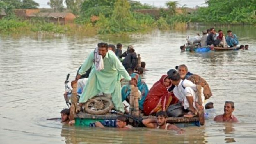 باكستانيون شردتهم الفيضانات يفرون على عوّامة مرتجلة في منطقة جعفر آباد بولاية بلوشستان في 8 أيلول/سبتمبر 2022
