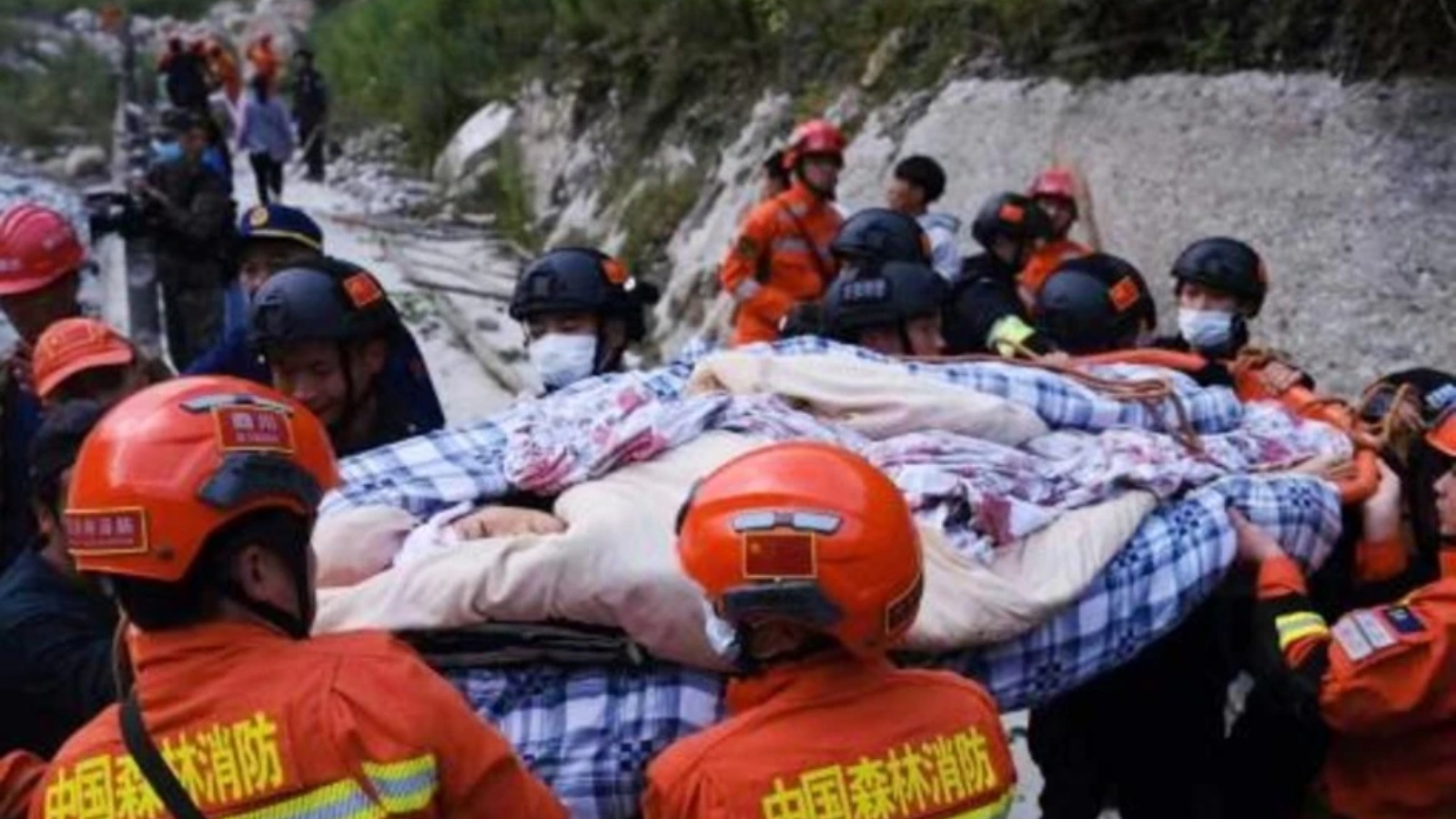عناصر الإنقاذ يحملون مصابة بتاريخ 5 سبتمبر 2022 بعد الزلزال الذي ضرب جنوب غرب الصين
