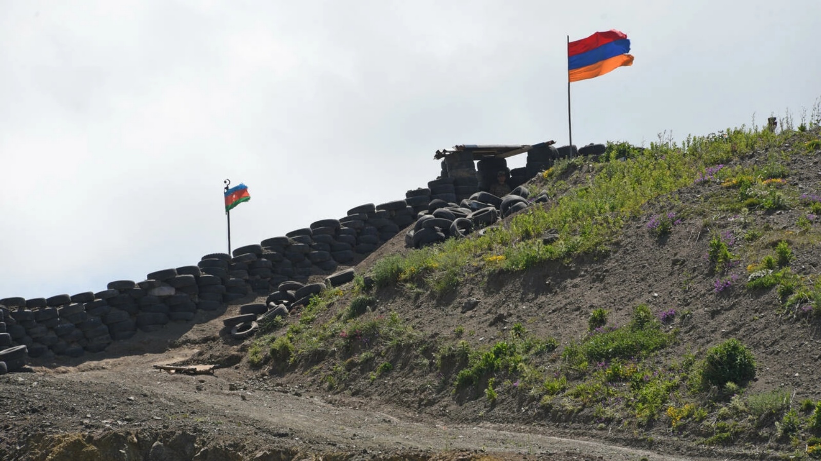 تُظهر هذه الصورة التي التقطت بالقرب من قرية سوتك، أرمينيا، في 18 يونيو 2021 ، علم أذربيجان (على اليسار) وعلم أرمينيا يرفرف عند نقطة تفتيش حدودية بين البلدين
