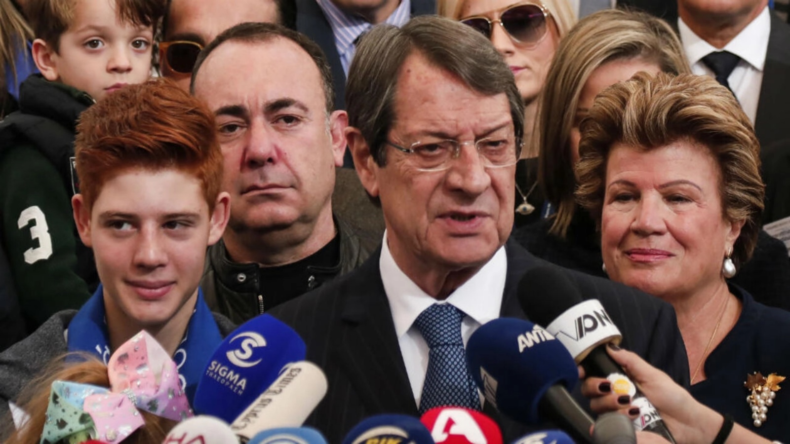 الرئيس القبرصي نيكوس أناستاسيادس (وسط الصورة) يقف بجانب زوجته أندري (يمين) وهو يخاطب وسائل الإعلام بعد الإدلاء بصوته في الانتخابات الرئاسية القبرصية 2018 في مركز اقتراع في مدينة ليماسول في 28 يناير 2018