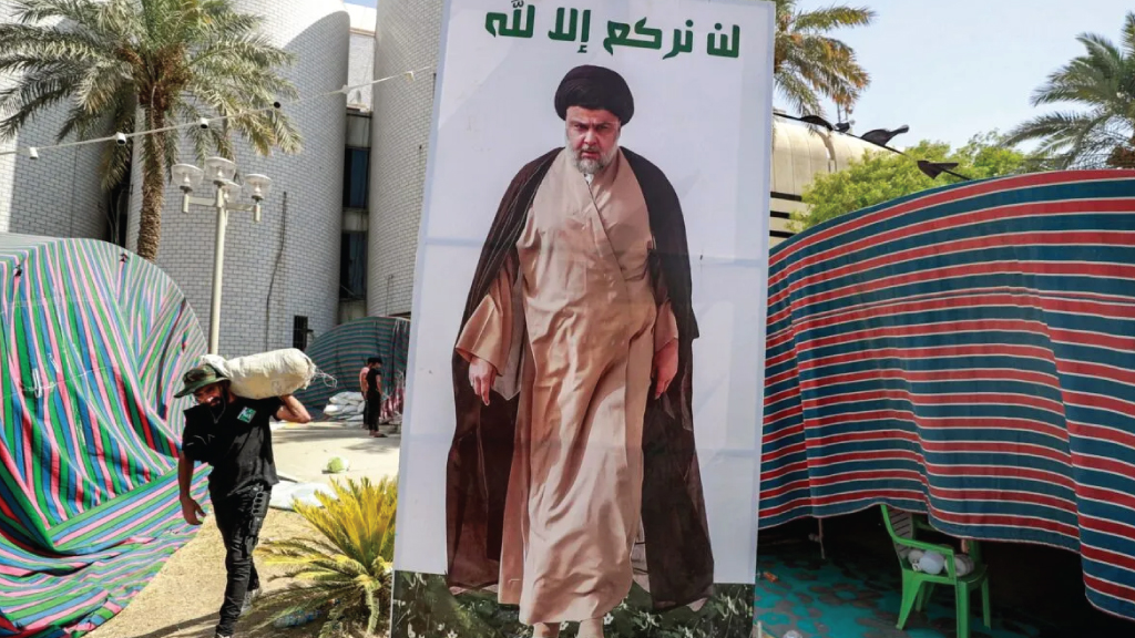 مناصر لرجل الدين الشيعي مقتدى الصدر يحمل أغراضا أثناء تفكيك معسكرهم في المنطقة الخضراء المشددة الحراسة في بغداد في 30 أغسطس 2022