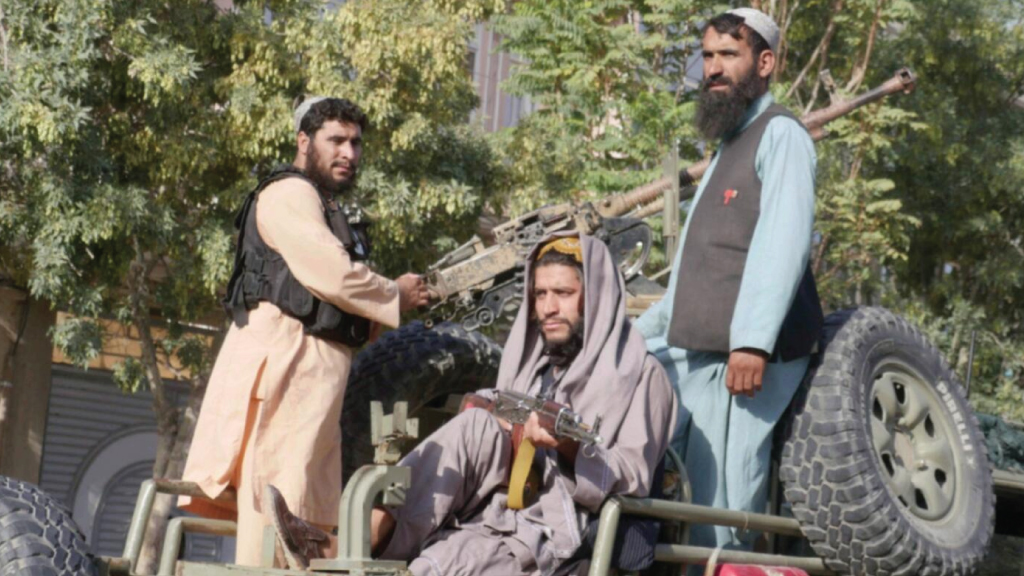 مقاتلو طالبان يقفون على ظهر مركبة أثناء قيامهم بالتفتيش 'من منزل إلى منزل'