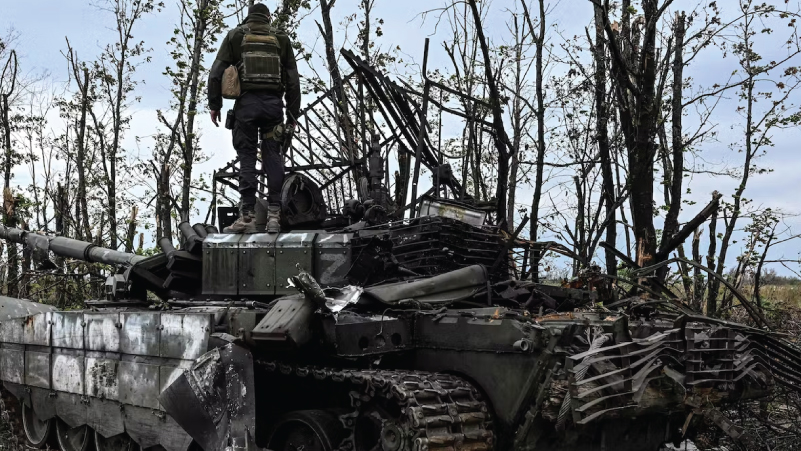 جندي أوكراني يعتلي برج دبابة روسية مدمرة في خاركيف