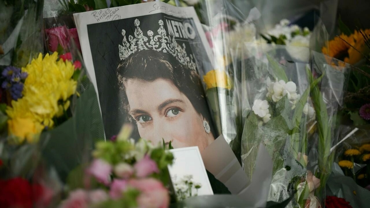صورة للملكة إليزابيث الثانية بين الورود التي وضعت على أبواب قصر باكينغهام تكريمًا للفقيدة