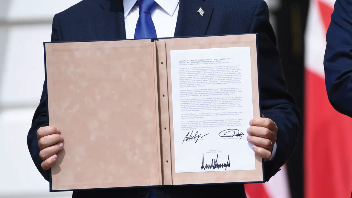 رئيس الوزراء الإسرائيلي بنيامين نتنياهو يحمل الوثيقة بعد مشاركته في توقيع اتفاقيات أبراهام حيث تعترف دولتا البحرين والإمارات العربية المتحدة بإسرائيل، في البيت الأبيض في 15 سبتمبر 2020