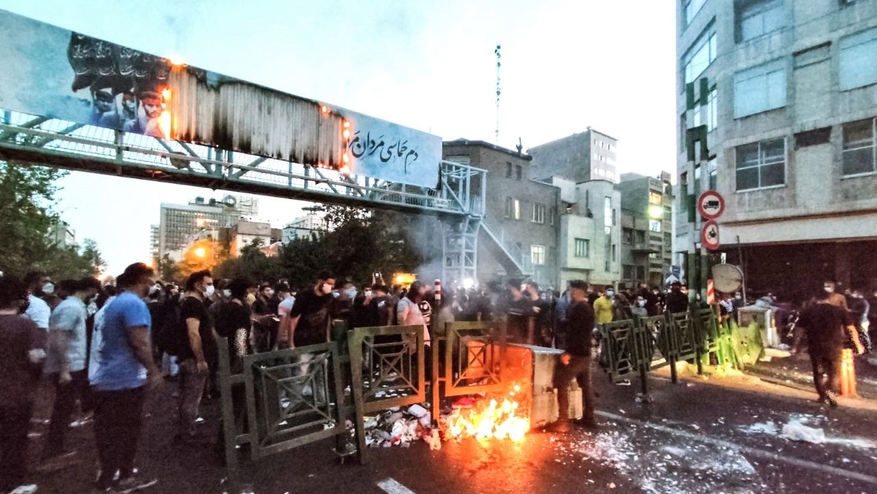 متظاهرون إيرانيون يحرقون صندوق قمامة في طهران خلال احتجاج على وفاة أميني، في 21 سبتمبر 2022