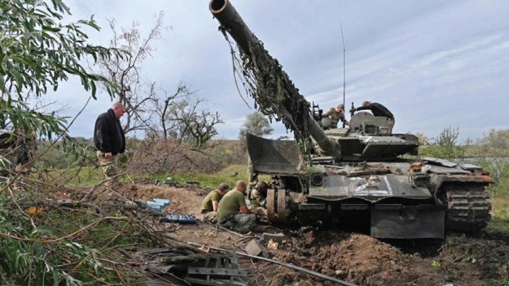 جنود أوكرانيون يحاولون إصلاح دبابة تخلى عنها الروس خلال انسحابهم في خاركيف، في 20 سبتمبر 2022