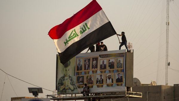 عراقيون مشاركون في حراك أكتوبر 2019 يرفعون العلم العراقي