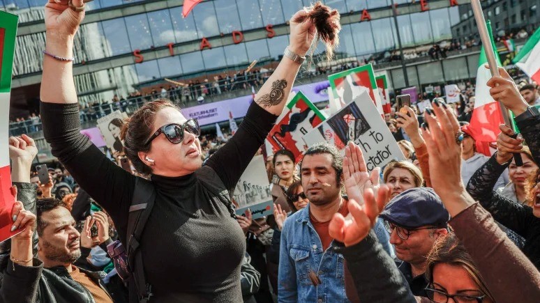 امرأة تقص شعرها خلال مظاهرة في سيرجيلس تورج في ستوكهولم ، السويد ، 24 سبتمبر 2022 ، بعد وفاة امرأة إيرانية بعد اعتقالها من قبل شرطة الآداب في طهران