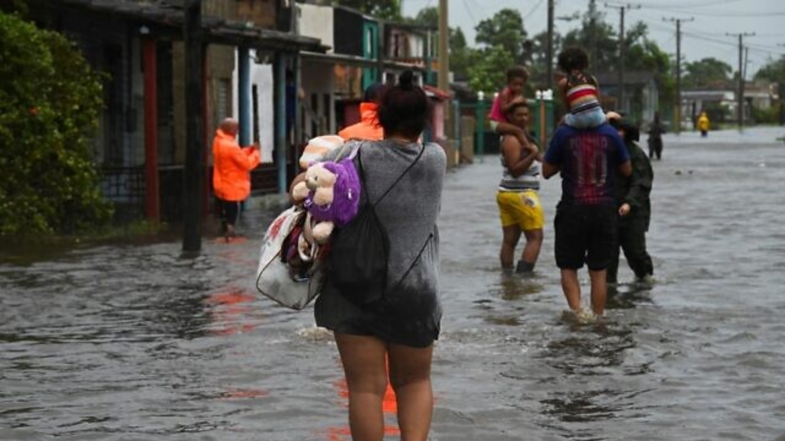 أشخاص يسيرون في شارع غمرته المياه في باتابانو، كوبا، أثناء مرور إعصار إيان، في 27 سبتمبر 2022