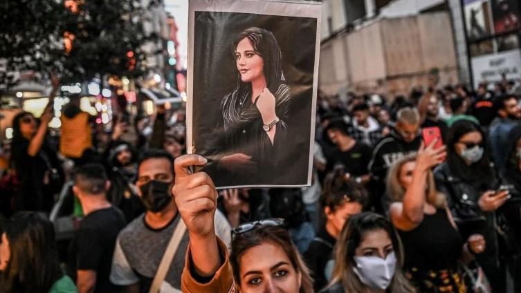 متظاهر يحمل صورة لماهسا أميني، شابة إيرانية توفيت بعد اعتقالها في طهران من قبل شرطة الأخلاق في الجمهورية الإسلامية، في إسطنبول، 20 سبتمبر 2022